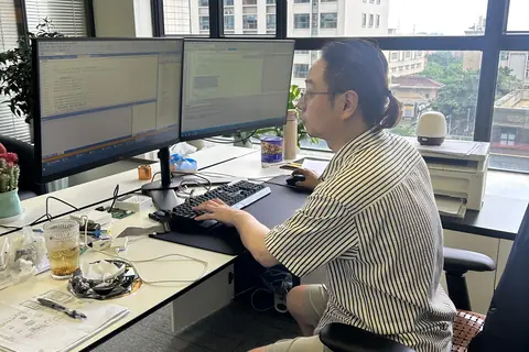 GOLDPRIME GAME R&D engineer at a dual-monitor development bench